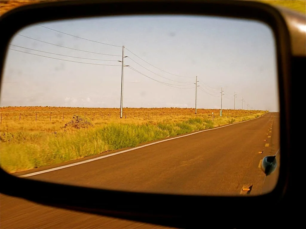 An open road reflected in a car mirror